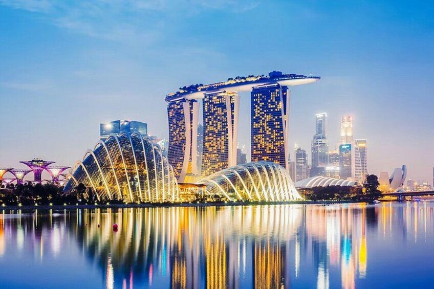 A city skyline with a prominent building with a curved top, a large dome-like structure, and a reflection in the water. 2
