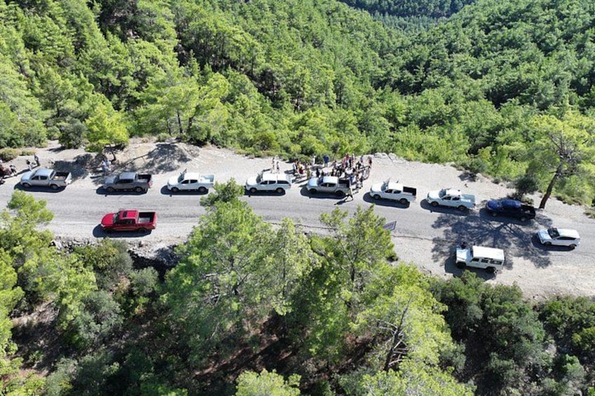 Un estacionamiento con vehículos y un grupo de personas. 5