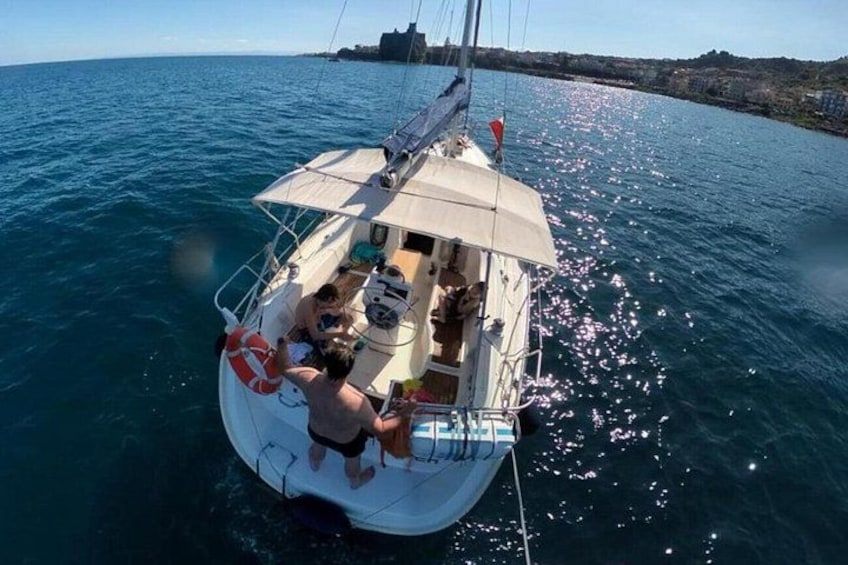 En segelbåt på vattnet med folk på däck, en livboj och en klar himmel. 2