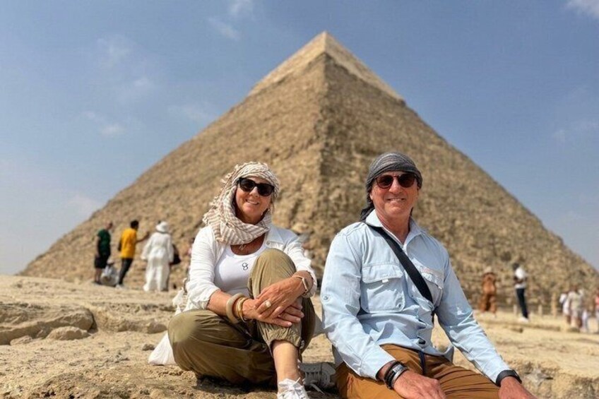 Due persone sedute di fronte alla Grande Piramide di Giza. 4