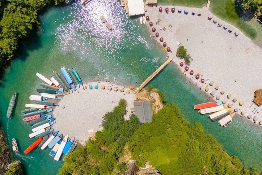 A beach with canoes lined up in a semi-circle, a dock, and a small pier. 5