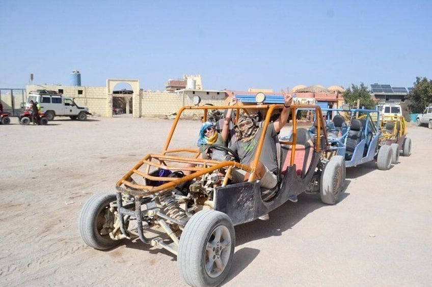 A desert scene with a vehicle towing a trailer. 4