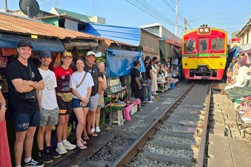 Un groupe de personnes se tient sur les voies ferrées, un train approchant. 1