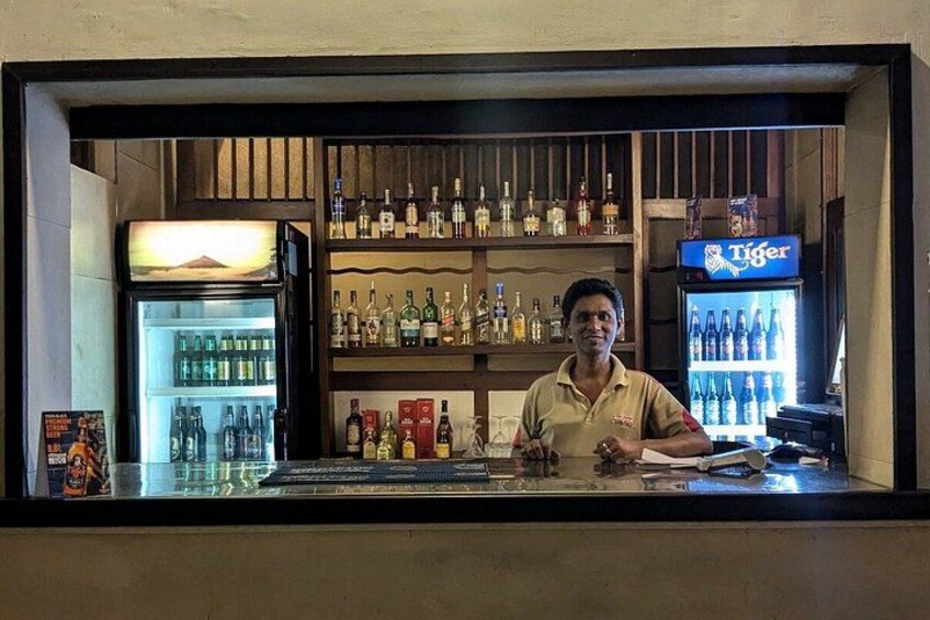 Een bar met flessenkasten en een bord met daarop 'Tiger Beer'. 4