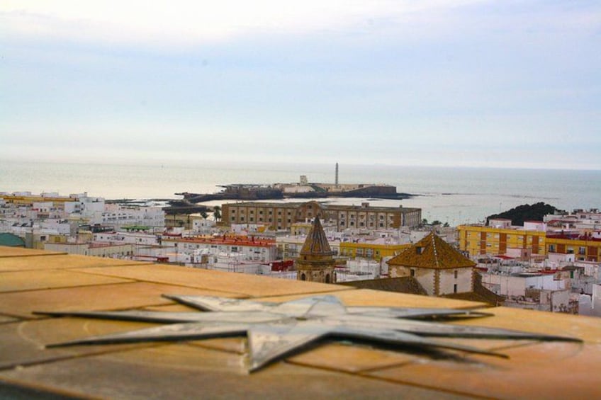A coastal cityscape with a prominent lighthouse, colorful buildings, and a clear view of the sea. 3
