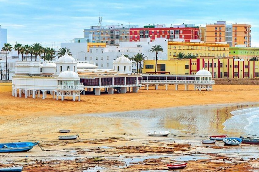 A beach with boats, a mosque, and colorful buildings. 4