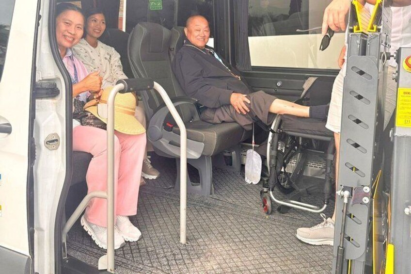 Een businterieur met passagiers, waaronder een rolstoel. 4