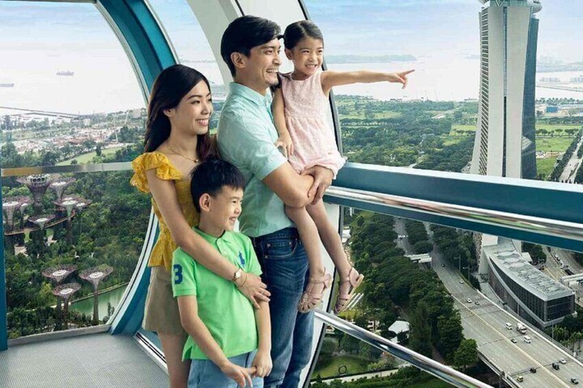 En familie på en glasudkigsplads med udsigt over bybilledet. 4