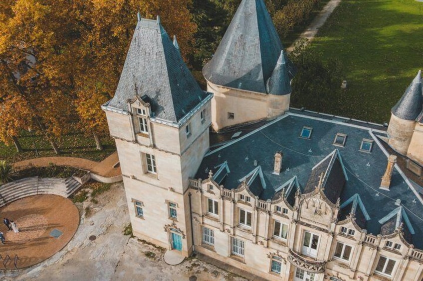 A large, historic building with multiple towers and a well-maintained lawn. 4