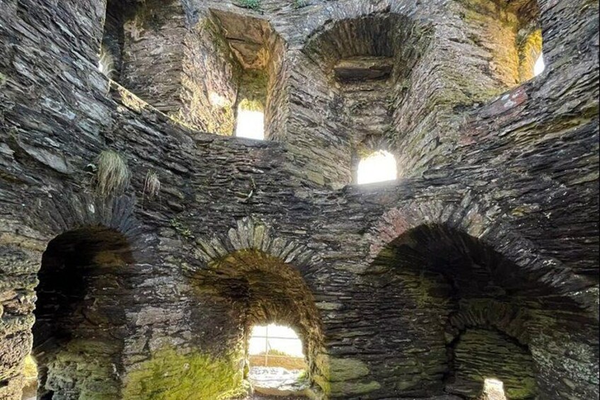 An underground stone structure with multiple arched openings and natural light filtering through. 2