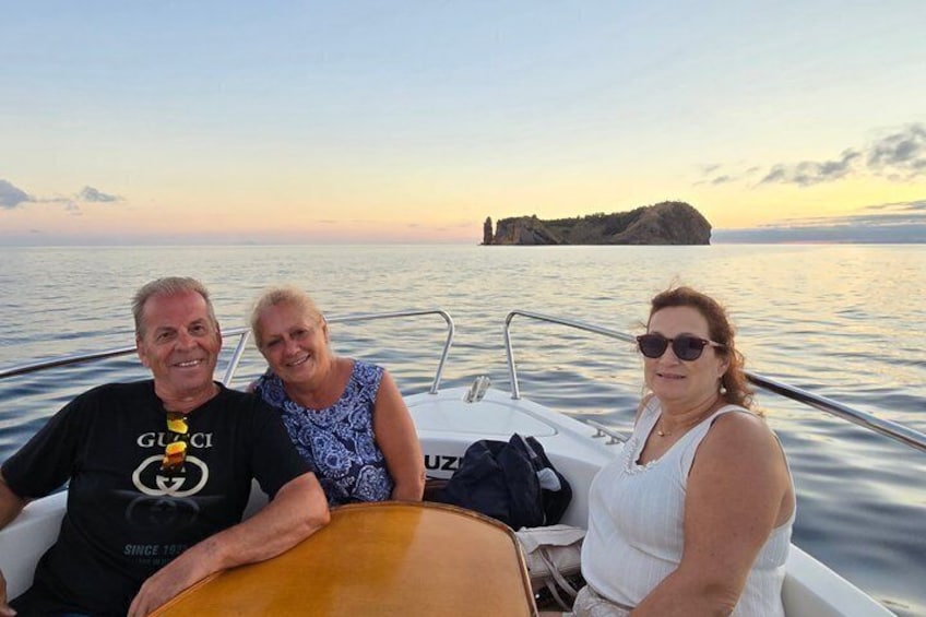 Three people on a boat with a rocky island in the background. 2