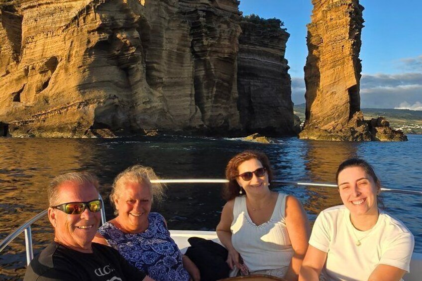 A group of people on a boat near large rock formations by the water. 4