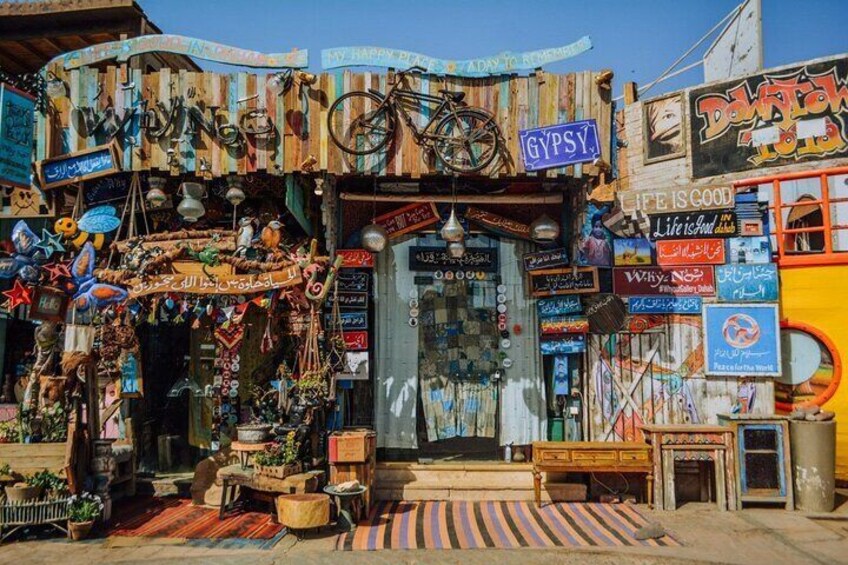 A colorful storefront with various signs and decorations, including a bicycle and a sign that says "GYPSY." 5