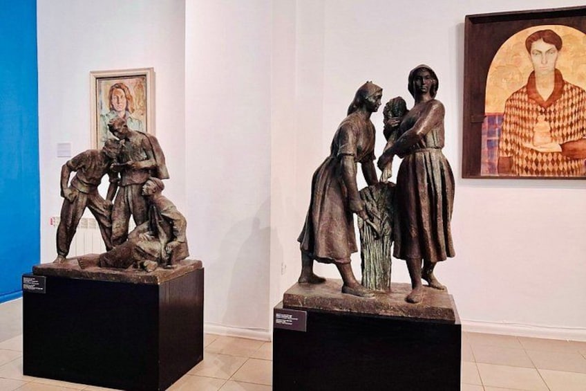 Two bronze sculptures on pedestals in an art gallery. 3