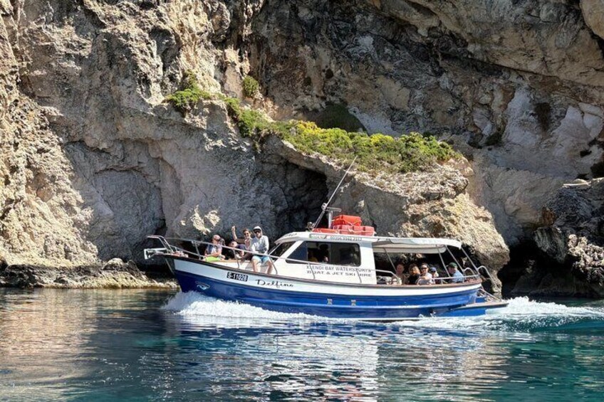 Una barca con passeggeri, circondata da scogliere rocciose e acque cristalline. 1