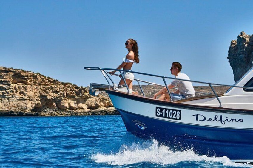 Una barca chiamata 'Delfino' con il numero di registrazione 'S-11028' sull'acqua. 3