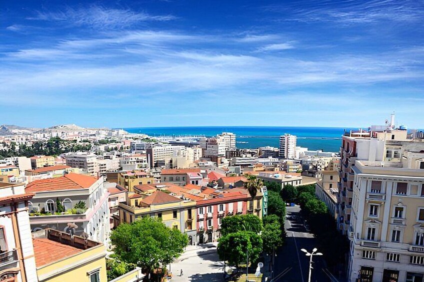Paesaggio costiero con edifici, cielo sereno e mare sullo sfondo. 1