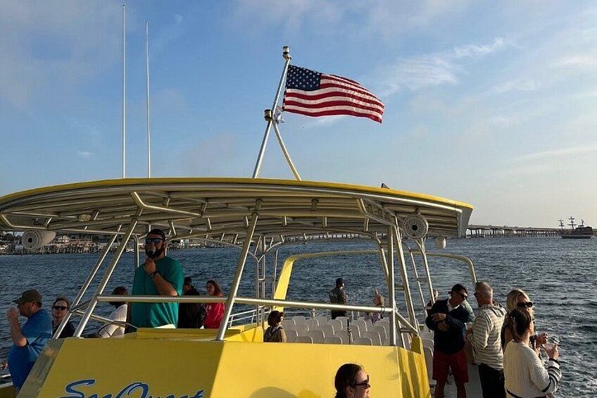 Un barco con bandera estadounidense, personas a bordo y un muelle al fondo. 3