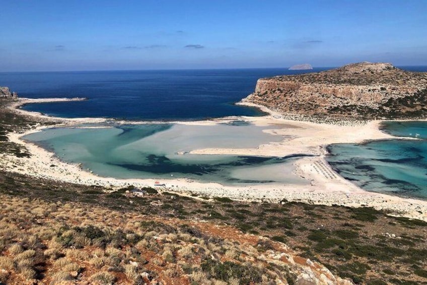 Un paisaje costero con una bahía, playa de arena y acantilados rocosos. 5