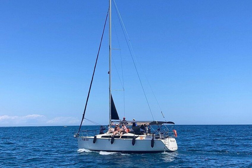 A sailboat on calm blue waters with a clear sky. 3