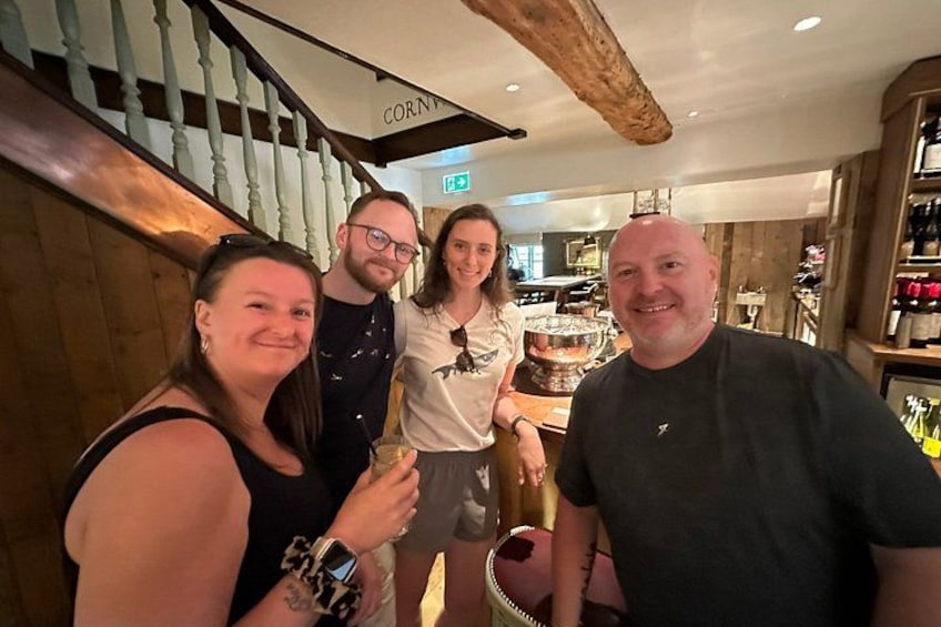 Un grupo de personas en un restaurante con decoración de madera y una escalera que dice 'CORN'. 2