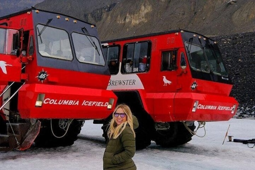 A red and black vehicle labeled 'COLUMBIA ICEFIELD BREWSTER' with a person standing in front of it. 1