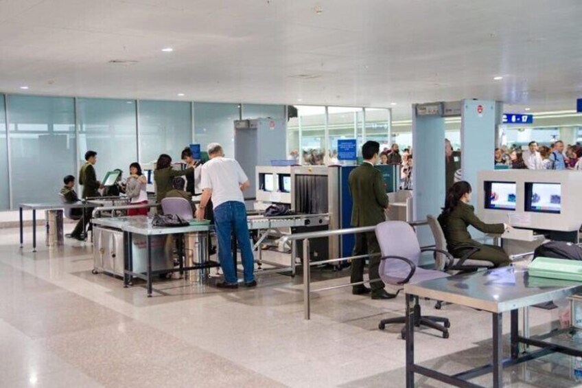 A busy airport check-in area with multiple desks and passengers. 3