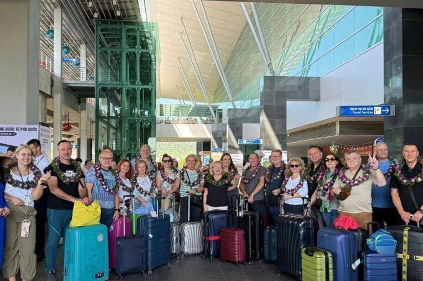 A group of people with luggage at an airport terminal. 1