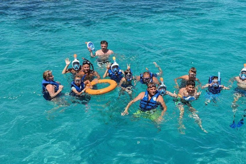 A group of people snorkeling in clear blue water. 2