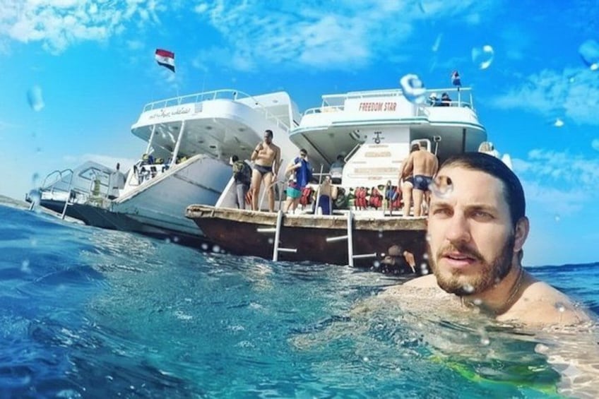 A boat named 'Freedom Star' with people on the deck and a flag in the background. 3