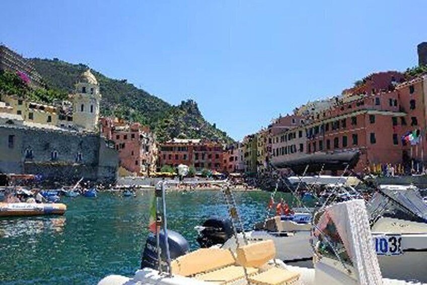 A coastal town with colorful buildings, boats docked in the harbor, and a clear blue sky. 3