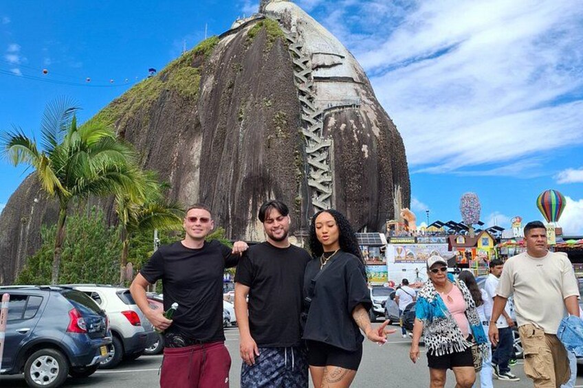 A large rock formation with people standing in front. 4