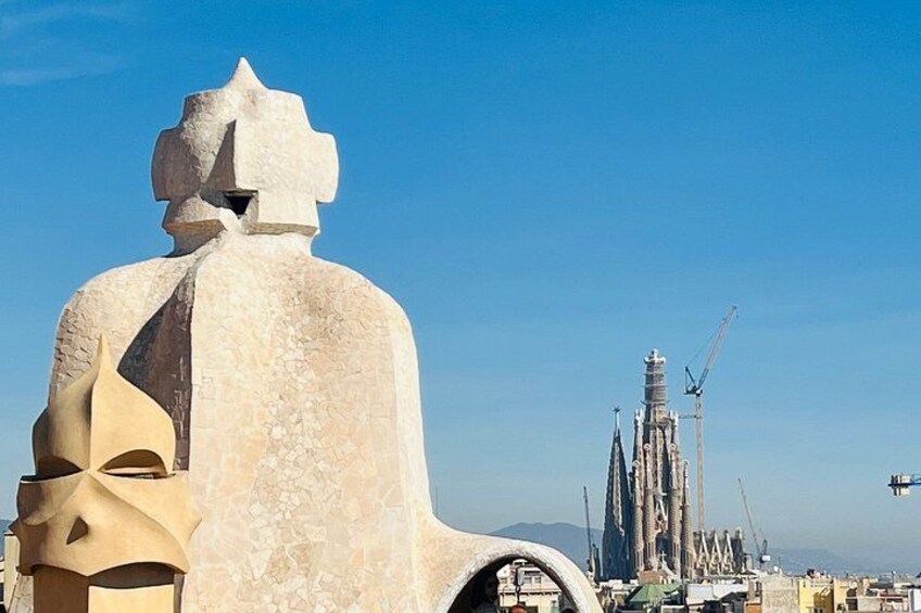 Une grande sculpture abstraite au premier plan, avec un bâtiment moderne en arrière-plan. 1