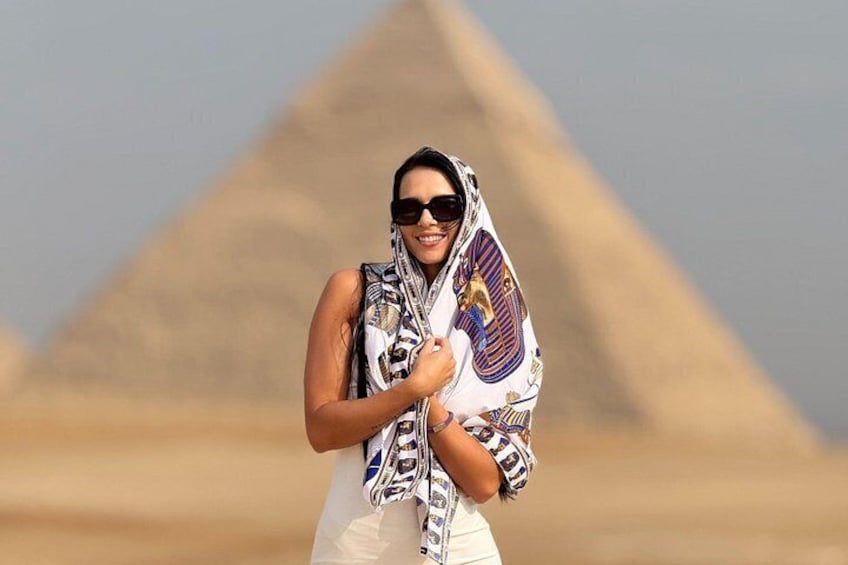 A person standing in front of a pyramid with a patterned scarf. 1