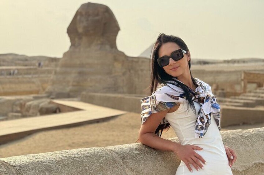 A person leaning on a stone structure with the Great Sphinx in the background. 2