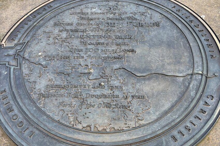 A circular plaque with inscriptions and a map. 3