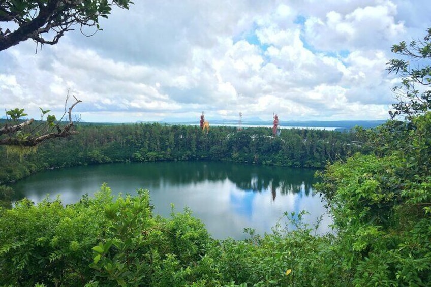 A lake surrounded by dense greenery, with a clear sky above. 5