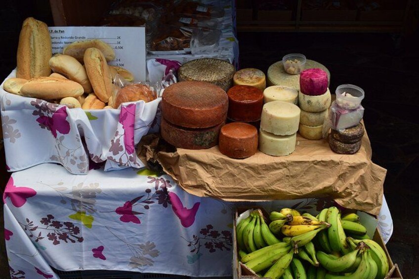 A table with various food items including bread, cheese, and bananas. 3