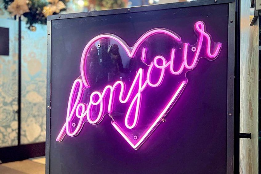 A neon sign with the words 'bonjour' in a heart shape. 4