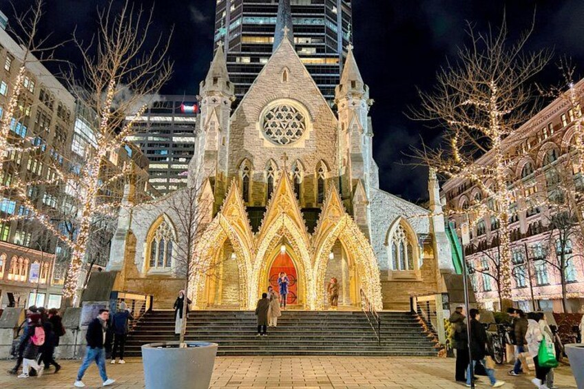A Gothic-style cathedral with a large rose window and a bell tower, surrounded by modern buildings and bare trees. 2