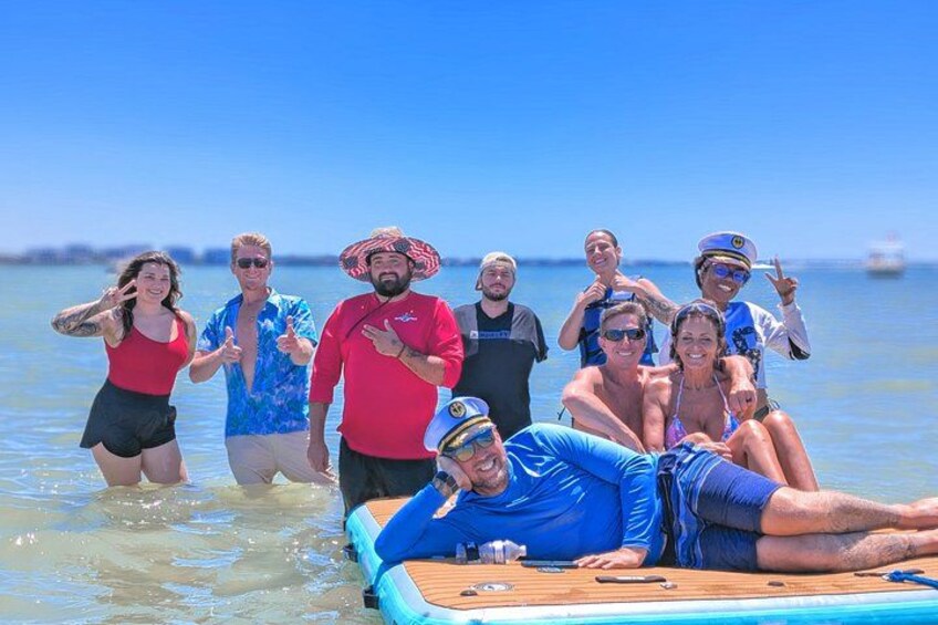 A group of people on a boat in a body of water with a clear sky. 5