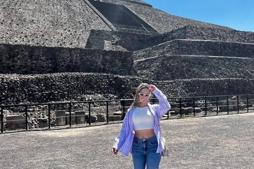 A person standing in front of a large pyramid structure. 5