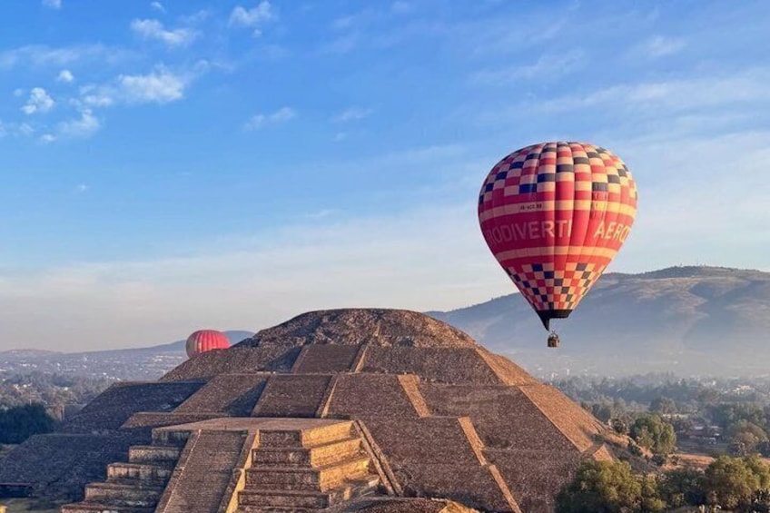 A pyramid with hot air balloons in the background. 3