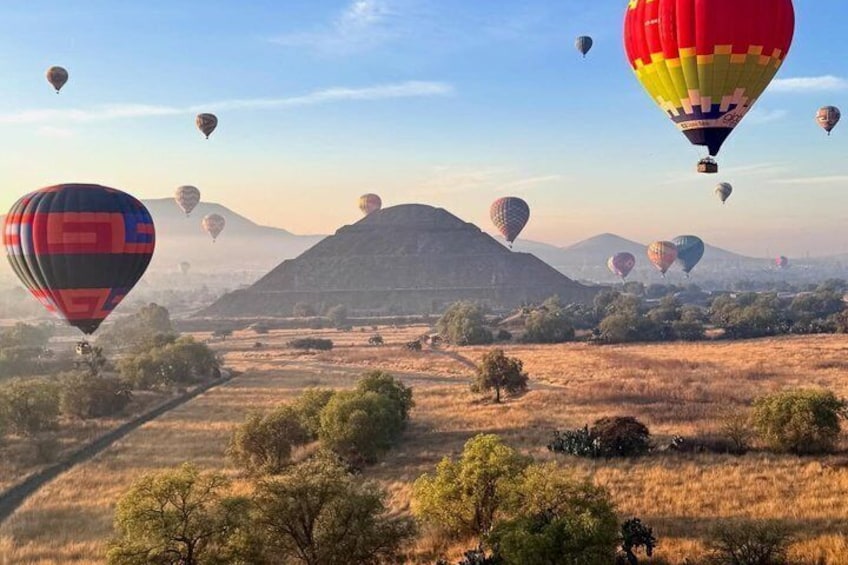 Hot air balloons over a hilly landscape with a clear sky. 4