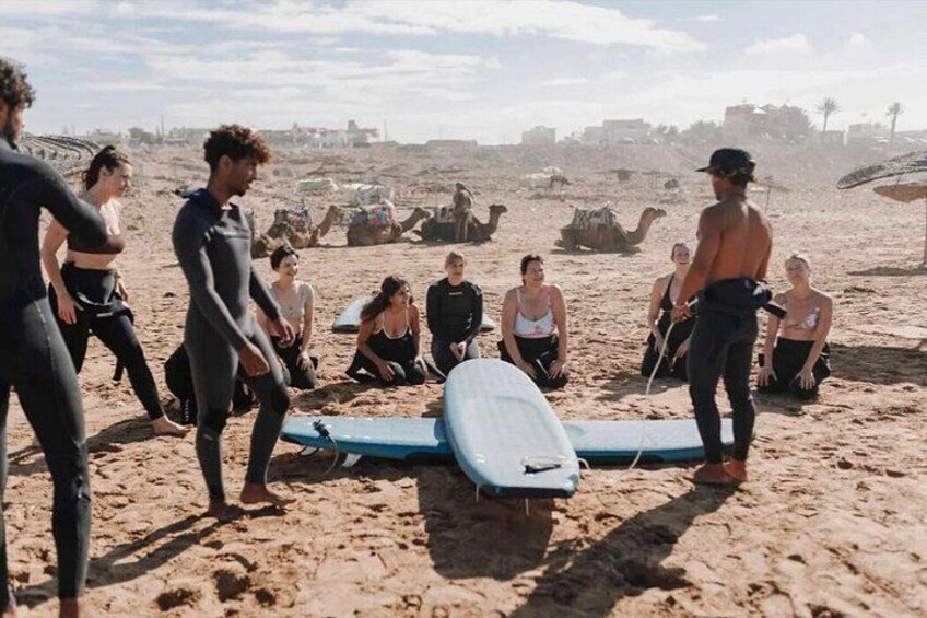 En gruppe mennesker på en sandstrand med surfboards. 2