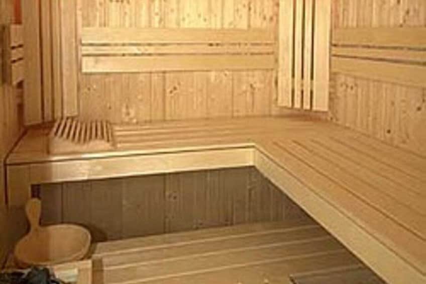 A wooden sauna with a bench, a slatted shower area, and a wooden wall. 5