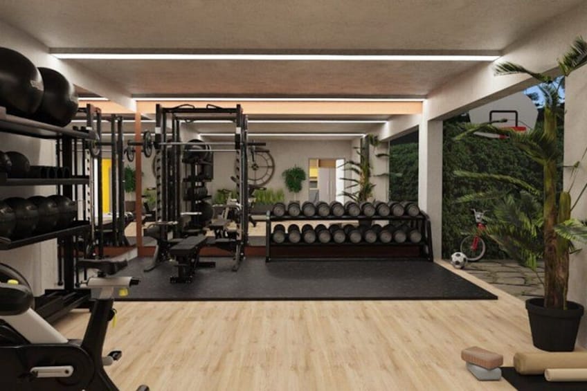 A gym with weightlifting equipment, a bench, and a wall-mounted rack of dumbbells. 3