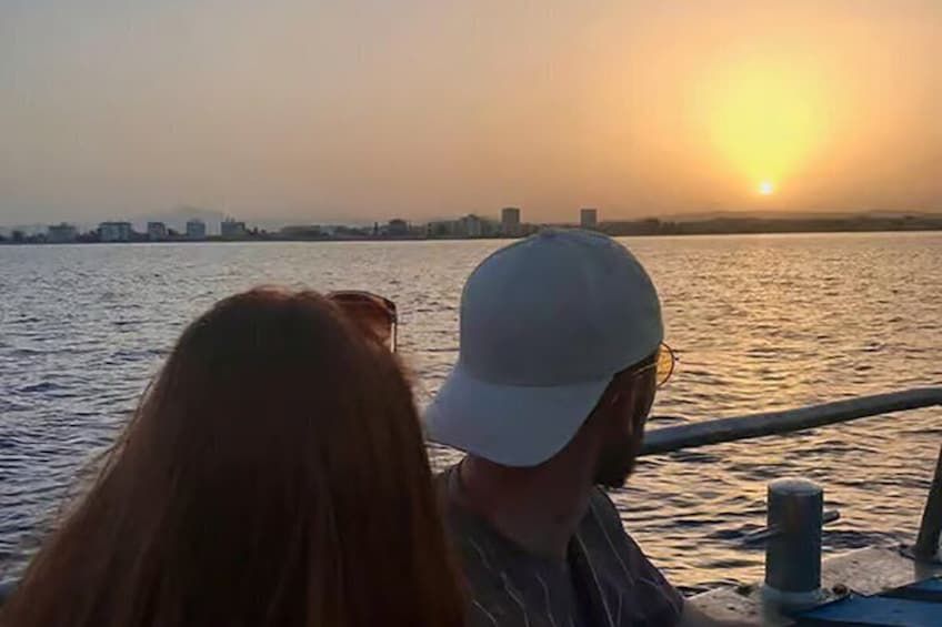 A sunset over a body of water with a city skyline in the background. 4