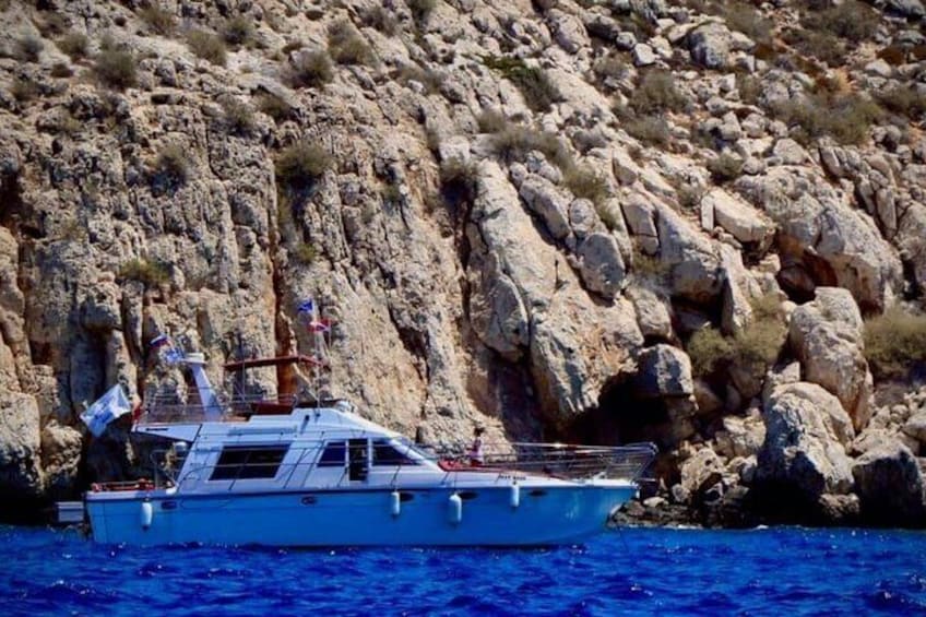 A small boat with flags on a rocky shore. 1