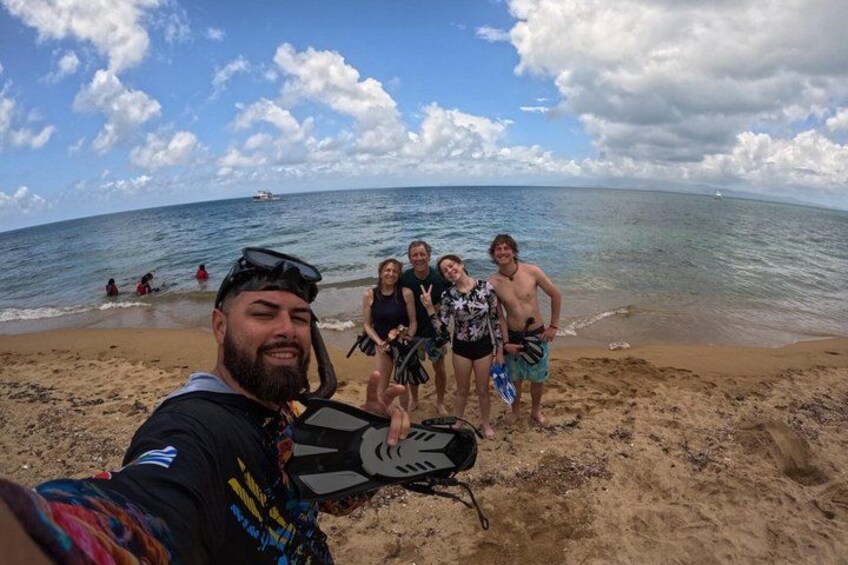A beach with people, including a person in a wetsuit and snorkel gear, and another in a black swimsuit. 3
